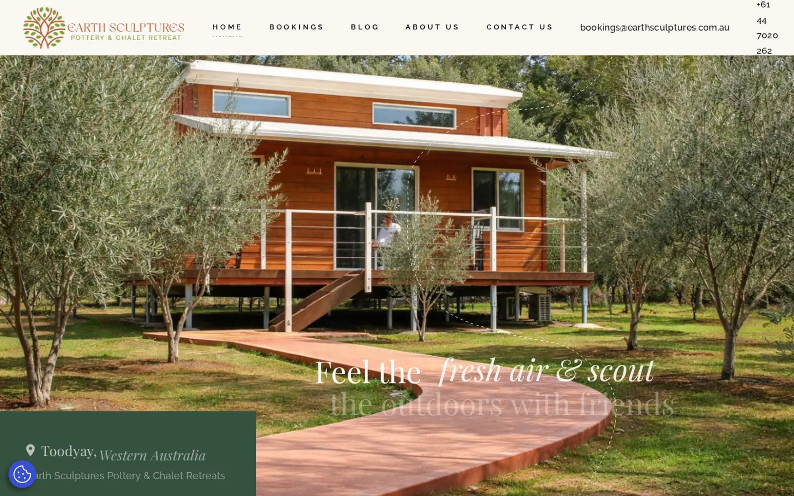 Earth Sculptures homepage showing a chalet among olive trees with bookings in the main menu
