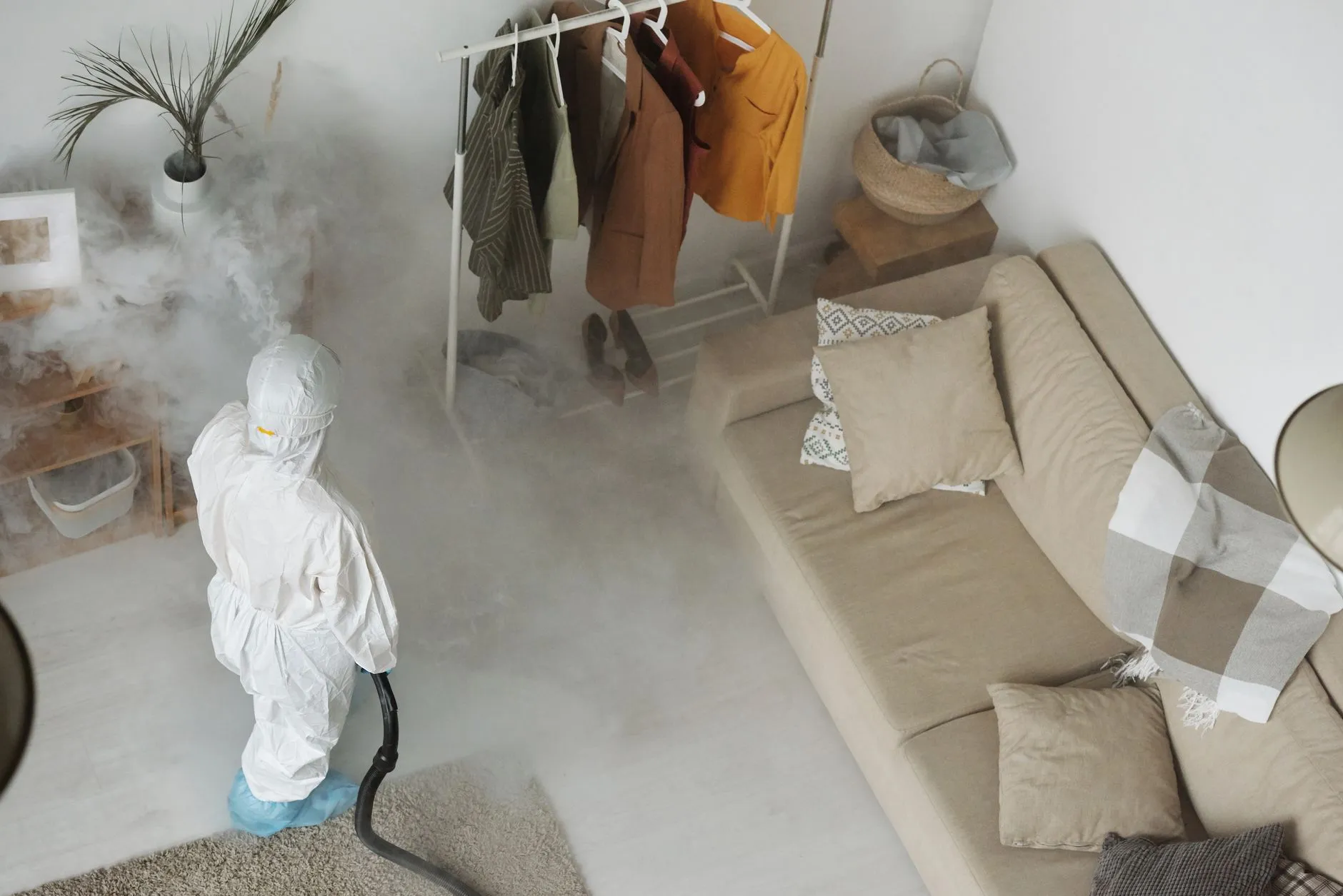 A pest control technician fumigating an indoor space