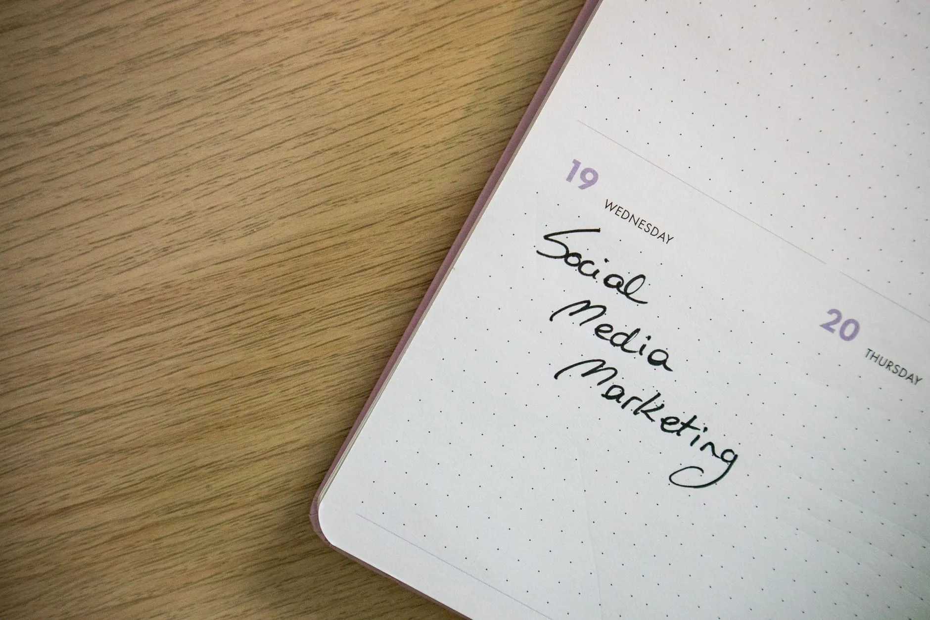 A notebook page with 'Social Media Marketing' handwritten on it, representing social media content plans