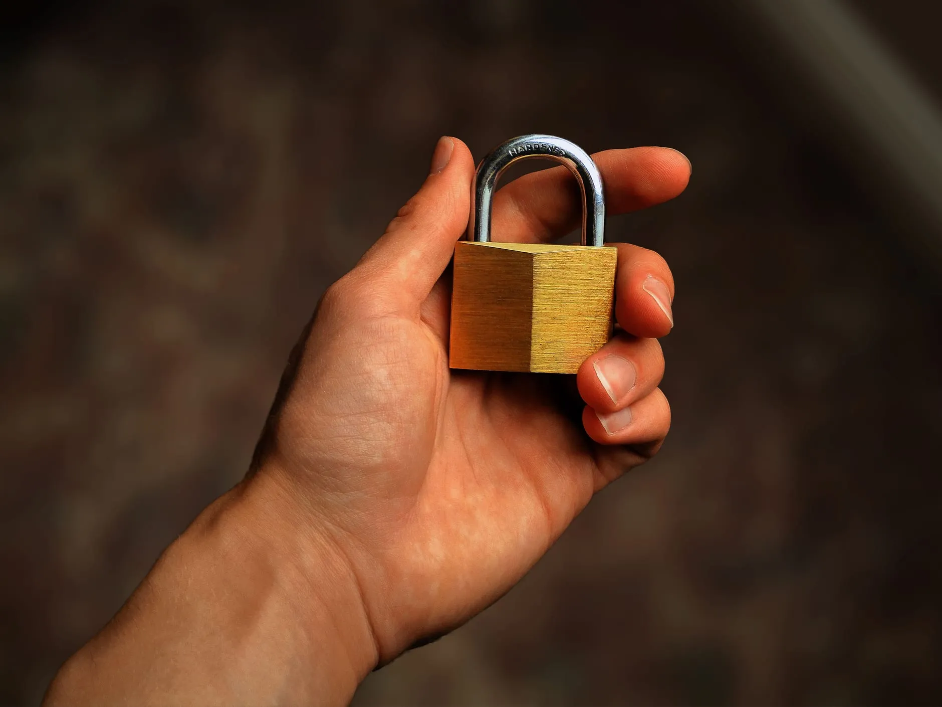 A hand holding a brass padlock, representing website security and speed optimisation in Perth